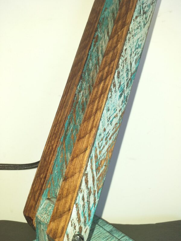 Découvrez notre lampe industrielle en bois "patine bleu", une création unique inspirée par la beauté du bois revalorisé. Chaleureuse, élégante et atypique, chaque lampe que nous créons est une ode à la forme naturelle du bois, avec ses veines et irrégularités. Avec un socle de 19 cm de long par 12 cm de large et une hauteur de 57.5 cm, cette lampe est à la fois pratique et artistique. La lampe présente une patine vieillie, mariant subtilement le bleu et le bois usé pour un charme authentique. L'abat-jour en corde, réalisé à la main, ajoute une touche artisanale. Personnalisez votre éclairage en optant pour une ampoule à filament LED. Le cordon d'alimentation en textile noir complète le look vintage. Tous les composants électriques sont homologués CE, et la douille standard convient à la plupart des ampoules à filament ou LED de classe énergétique A. En choisissant cette lampe, vous optez pour une pièce à la fois esthétique, écologique et unique, créée avec passion et respect pour le bois.